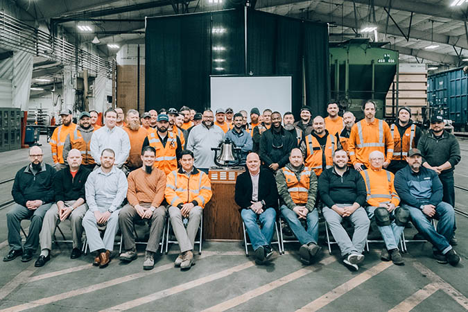 Members of the Twin Cities Division Mechanical team gather around the Safety Bell they’ve just been awarded at BNSF’s Northtown Yard in Minneapolis, Minnesota.